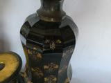 a black and gold vase sitting on a table next to a pair of black and gold vases