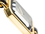 a gold watch with a black face and a chain around it