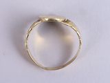 an image of a gold ring on a white surface