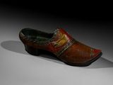 an old wooden clogger with a red and yellow design on the side