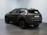 the back of a grey jeep compass parked in a room