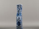 a blue and white vase sitting on a gray surface