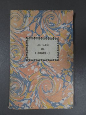 an old book sitting on top of a table covered in paper