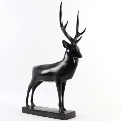 statue d'un cerf posée sur un socle en bois, sur fond blanc