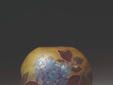 a yellow vase with blue flowers on it sitting on a table