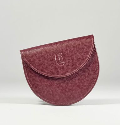 un petit sac à main rouge orné d'un logo monogramme sur le devant