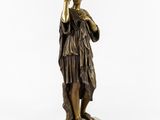 a bronze statue of a woman holding a glass in her hand