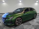La voiture verte est garée sur un sol à damier, dans une pièce.