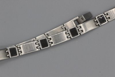 une image représentant un bracelet en argent orné de carrés noirs