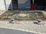 un grand tapis posé à même le sol, à côté de deux urnes en pierre