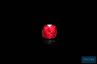 a close up of a red diamond on a black surface