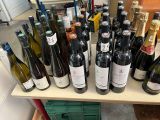 de nombreuses bouteilles de vin alignées les unes à côté des autres sur une étagère