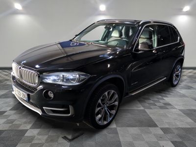 the black bmw suv is parked on a checkered tile floor