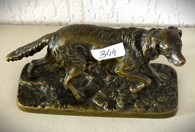 bronze statue of a dog with a tag on it ' s collar