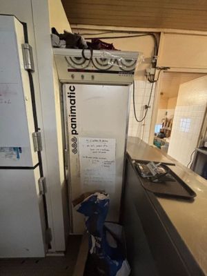 un réfrigérateur dans un coin de la cuisine, à côté d'un plan de travail