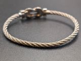 a close up of a silver rope bracelet on a table