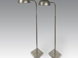 une paire de lampadaires en métal sur pied, devant un fond blanc