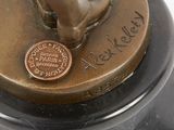 a bronze statue of a dog with a penny on it