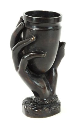 un vase noir tenu par une main