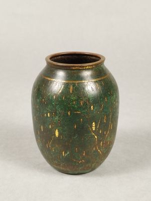 a green vase sitting on a table with a white background