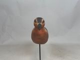 sculpture of a bird on a wooden stand on a white background