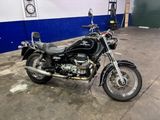 a black motorcycle parked in a garage with a clock on the wall