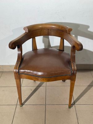 a brown leather chair sitting on a tile floor