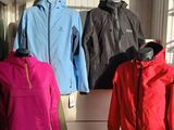 several jackets are displayed on a rack in a clothing store