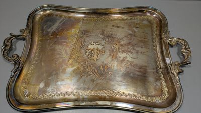 un plateau ancien en argent aux poignées ouvragées posé sur une table