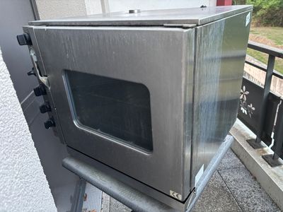 a silver microwave sitting on top of a metal stand