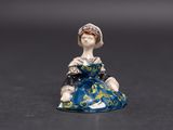 une petite figurine représentant une femme assise sur une table