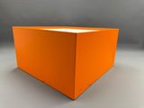une boîte orange posée sur une table blanche