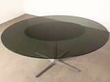 an image of a glass table with a metal base and a circular glass top