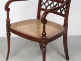 une image représentant une chaise en bois avec une assise et des accoudoirs tressés