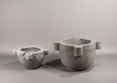 deux pots en ciment posés l'un à côté de l'autre sur une table