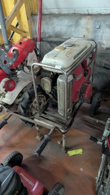 un petit générateur rouge et blanc dans un garage