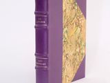 a purple book that is sitting on a white surface