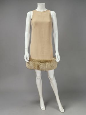 un mannequin vêtu d'une robe beige à col en fourrure