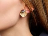 a close up of a woman wearing a pair of earrings
