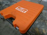 une valise orange posée sur une dalle de béton