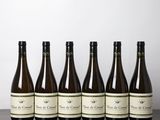 six bouteilles de vin sont alignées sur une table en bois