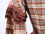 an image of a woman wearing a plaid dress with ruffled sleeves