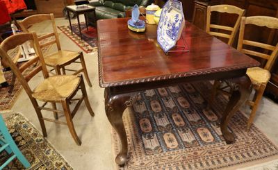 une table avec des chaises et un vase posé dessus
