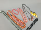 six perles de couleurs différentes sont disposées en ligne sur une surface blanche