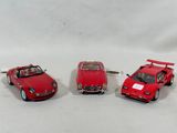 three toy cars sitting next to each other on a white surface