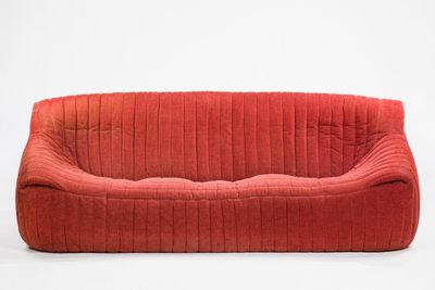 an image of a red couch sitting on top of a white floor