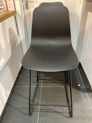 une chaise noire placée dans une cuisine, à côté d'un plan de travail