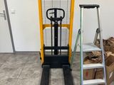 un chariot élévateur garé à côté d'un tas de bois