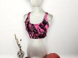 mannequin féminin portant un brassière de sport rose et une casquette rose