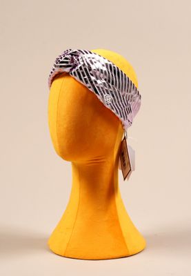 une tête de mannequin jaune coiffée d'un bandana noir et blanc